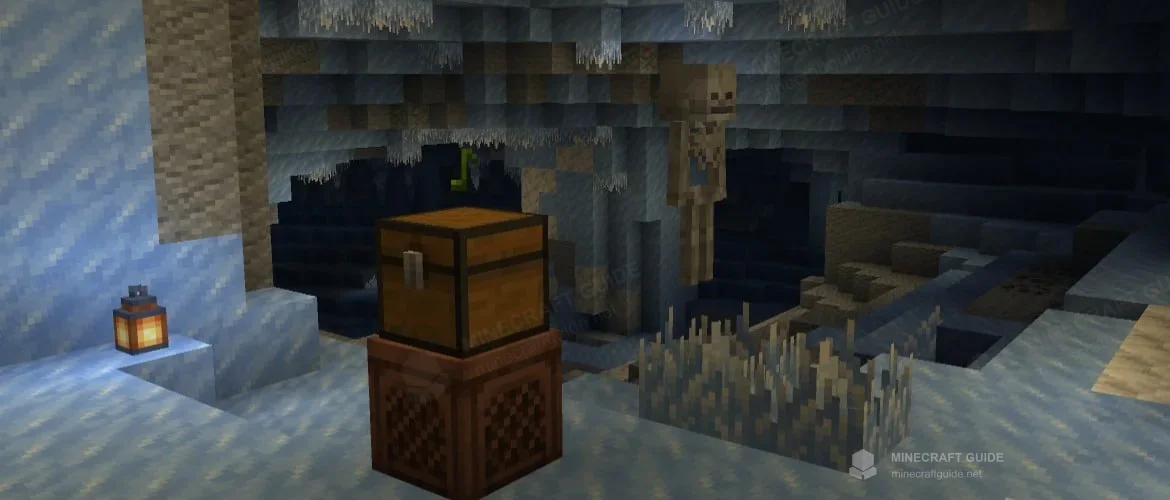 A chest placed on a jukebox in an icy cave, with a skeleton and a lantern in the background